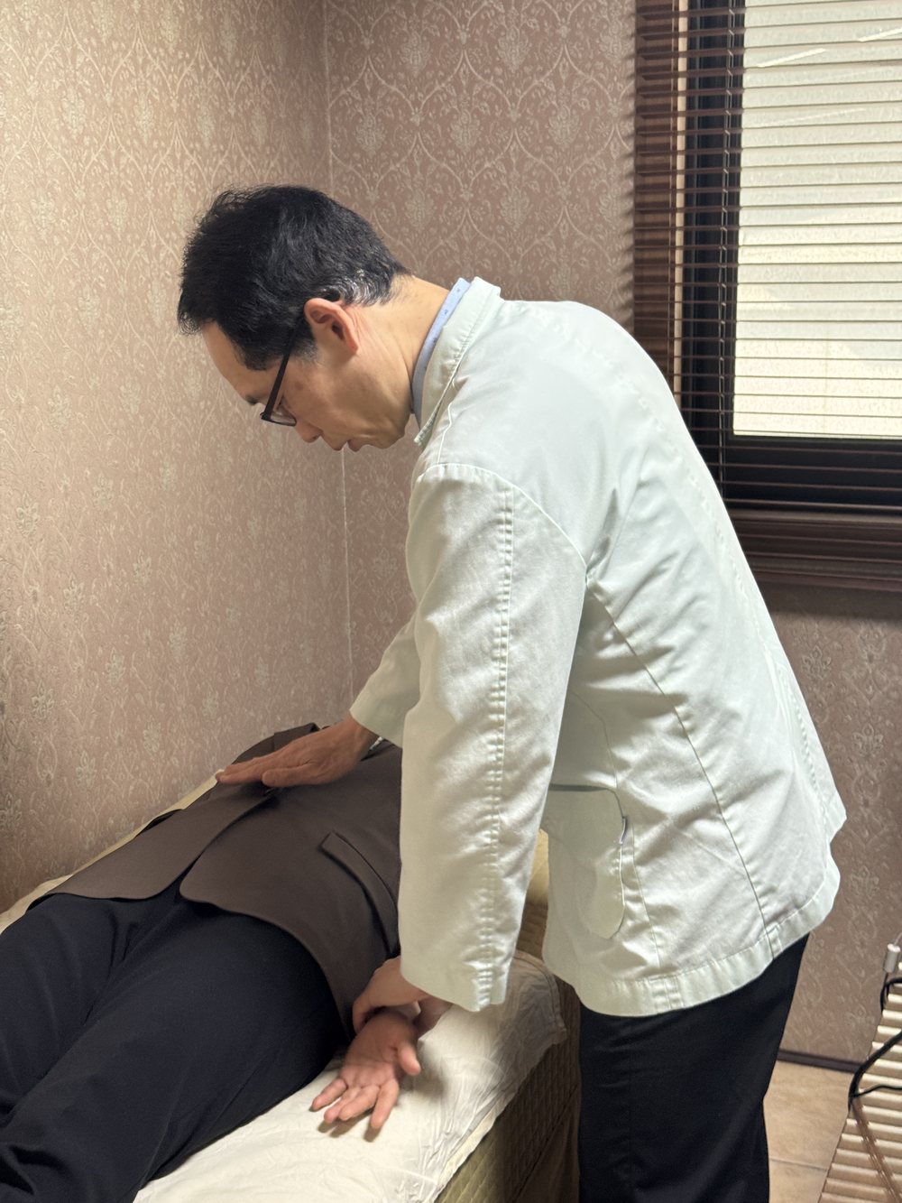환자의 배를 살피는 원장